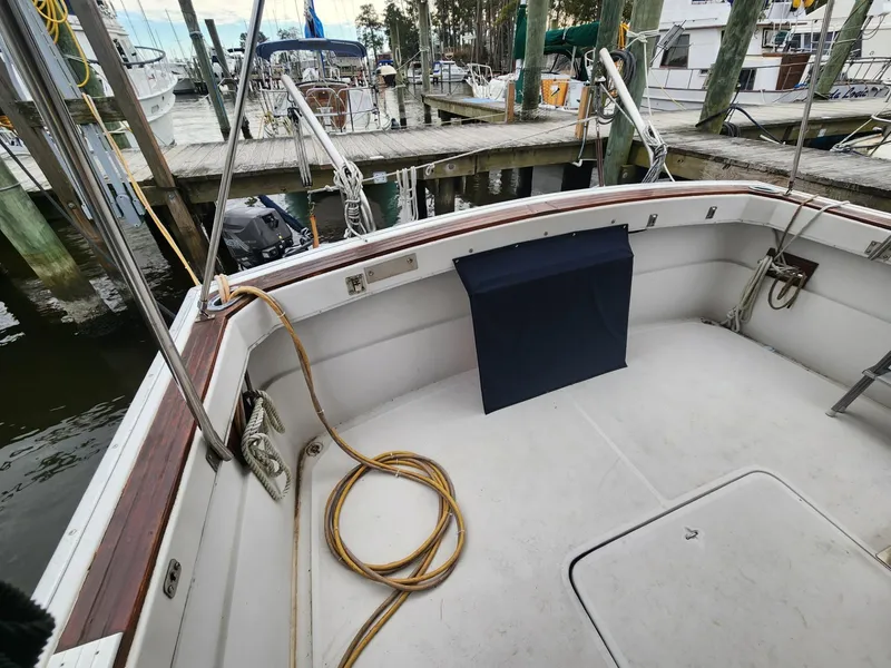 Slide: The Image of 1981 Mainship 34 Trawler docked, showing spacious deck area with coiled rope. - 9
