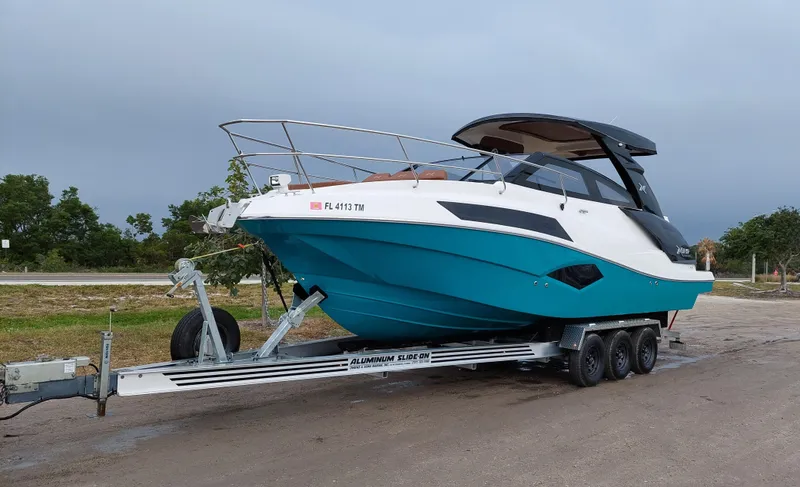 Slide: The Image of 2023 NX Boats NX340 on trailer, sleek design, vibrant blue hull. - 1