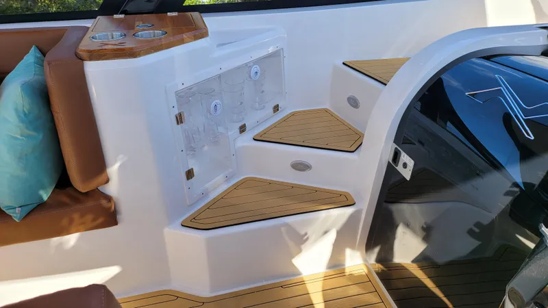 Slide: The Image of 2023 NX Boats NX340 interior with wooden steps and seating area. - 11