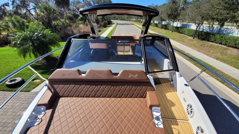 Slide: The Image of 2023 NX Boats NX340 with luxurious seating and sleek design on a sunny day. - 12