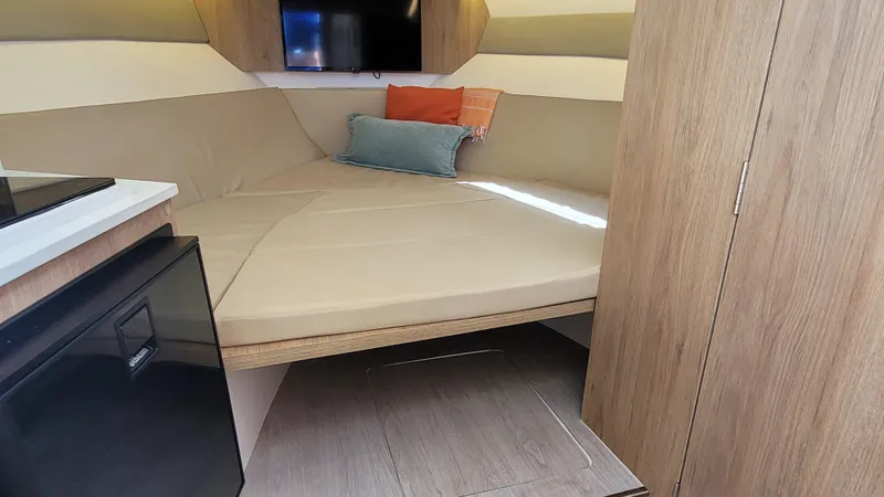 Slide: The Image of 2023 NX Boats NX340 interior cabin with bed, pillows, and modern furnishings. - 18