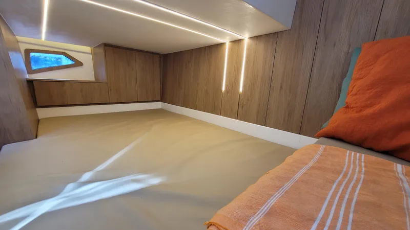 Slide: The Image of 2023 NX Boats NX340 cabin interior with modern wood paneling and cozy bedding. - 20