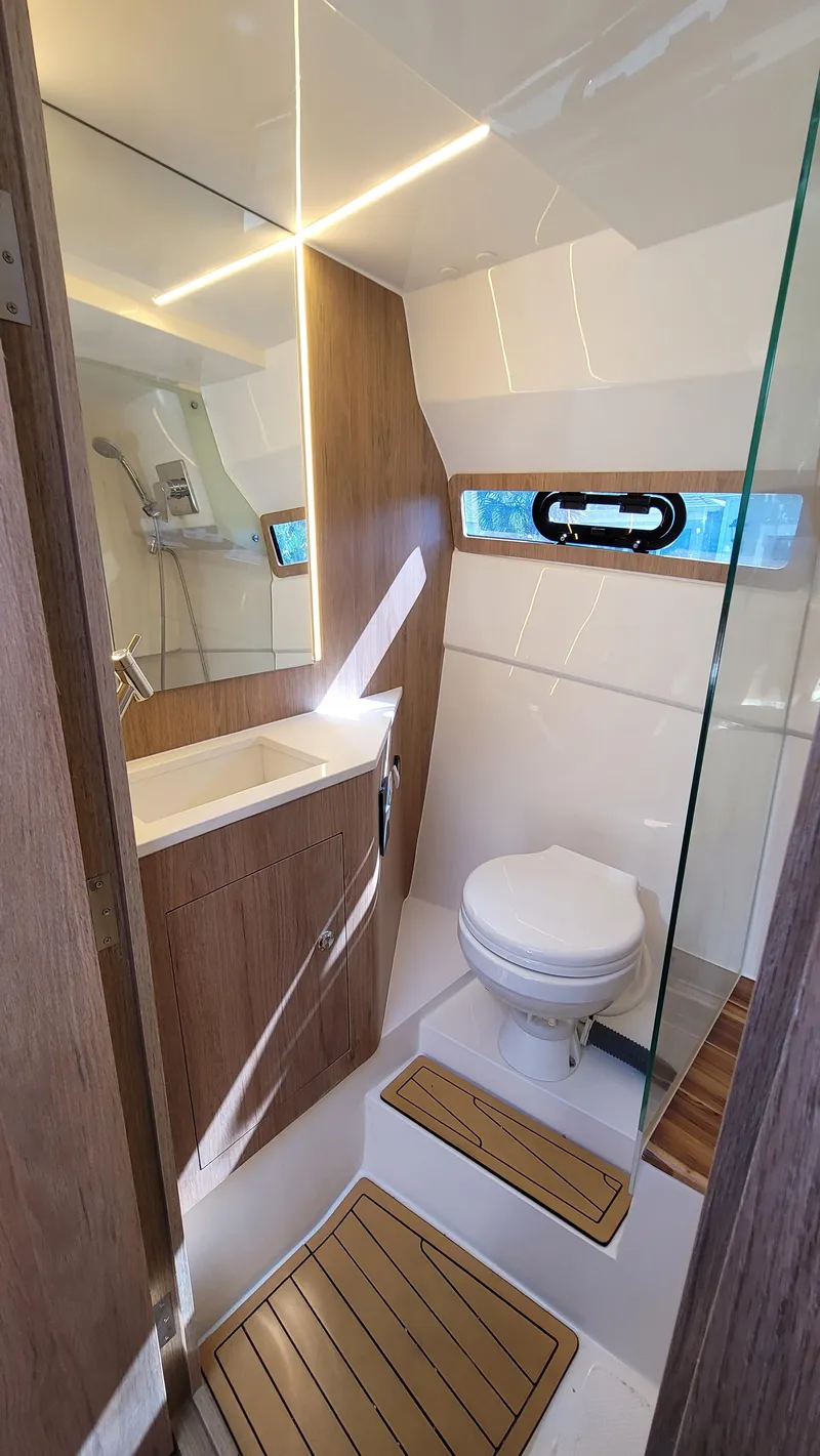 Slide: The Image of 2023 NX Boats NX340 bathroom with modern design, featuring wood accents and compact layout. - 24