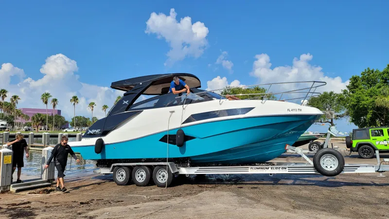 Slide: The Image of 2023 NX Boats NX340 on trailer, vibrant blue and white design, ready for launch. - 3