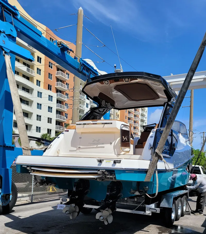 Slide: The Image of 2023 NX Boats NX340 on trailer, urban background, blue sky. - 5