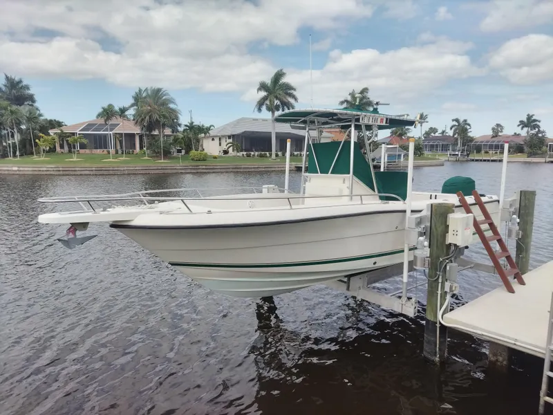 Slide: The Image of 2003 Pursuit 2470 Center Console boat docked by waterfront homes. - 0