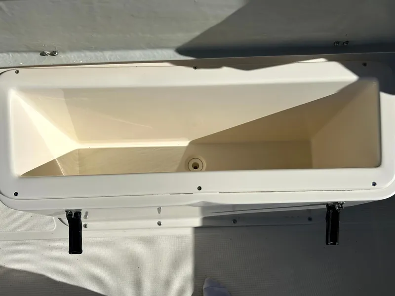 Slide: The Image of 2003 Pursuit 2470 Center Console boat storage compartment, open and empty. - 11