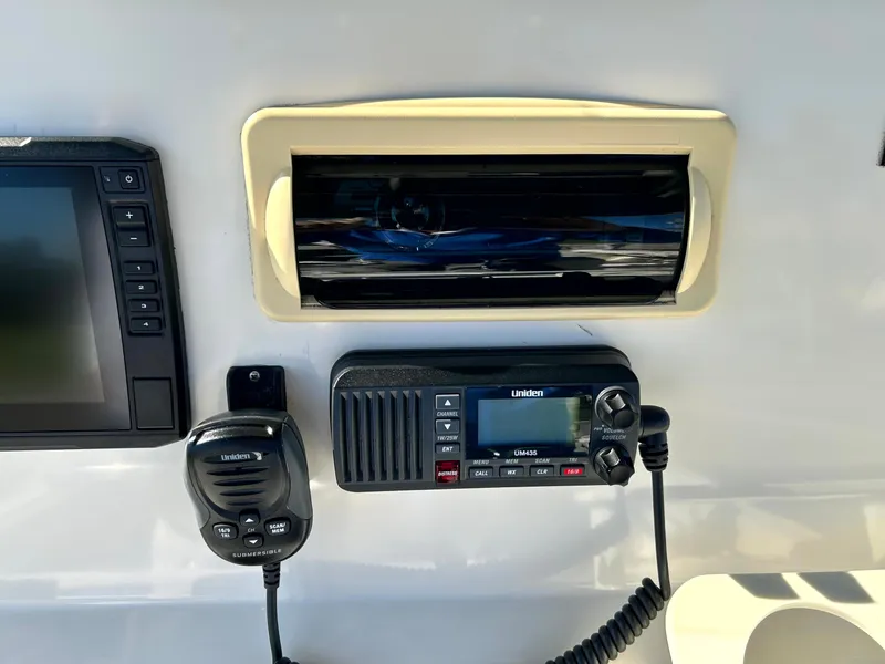 Slide: The Image of Control panel of a 2003 Pursuit 2470 Center Console boat with radio and display. - 14