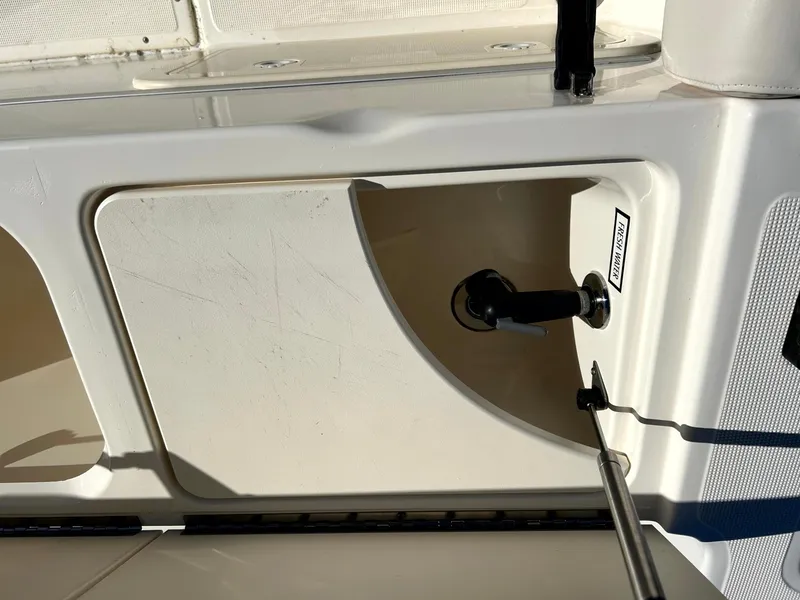 Slide: The Image of 2003 Pursuit 2470 Center Console boat compartment with latch, white interior. - 18