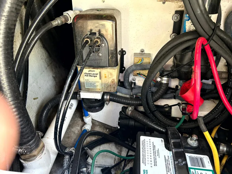 Slide: The Image of Engine compartment of a 2003 Pursuit 2470 Center Console with visible wiring and battery. - 22
