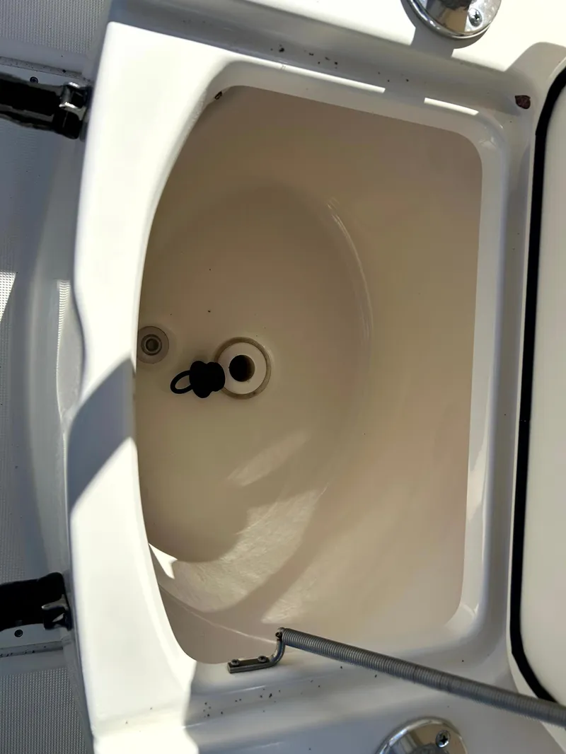 Slide: The Image of 2003 Pursuit 2470 Center Console boat storage compartment, open and empty. - 24
