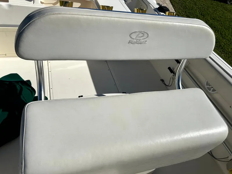 Slide: The Image of 2003 Pursuit 2470 Center Console boat seat with white upholstery and metal frame. - 26