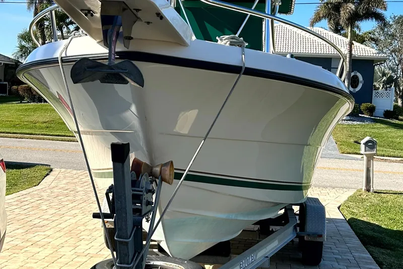 Slide: The Image of 2003 Pursuit 2470 Center Console boat on trailer in residential driveway. - 32