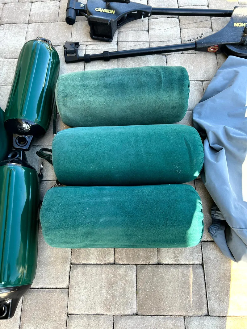 Slide: The Image of Green boat fenders and equipment on a paved surface, Pursuit 2470 Center Console accessories. - 6