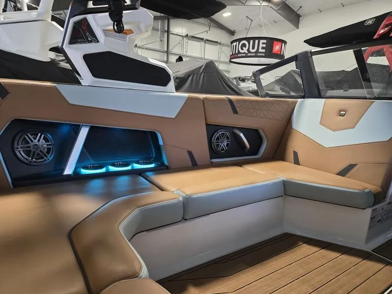 Slide: The Image of 2023 Nautique Super Air Nautique GS20 interior with tan seating and illuminated speakers. - 10