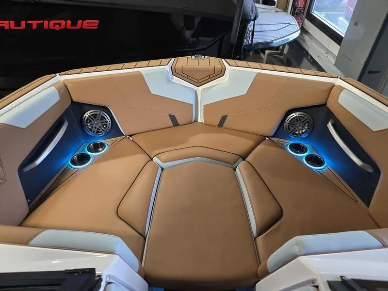 Slide: The Image of 2023 Nautique Super Air Nautique GS20 interior with tan seating and blue LED lighting. - 11