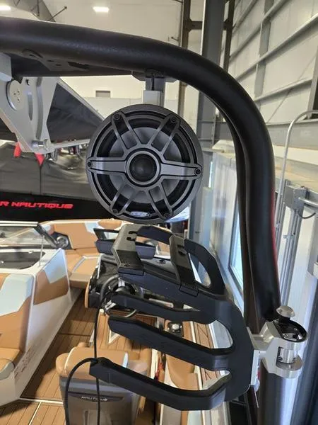 Slide: The Image of 2023 Nautique Super Air Nautique GS20 boat speaker and wakeboard rack in a showroom. - 14