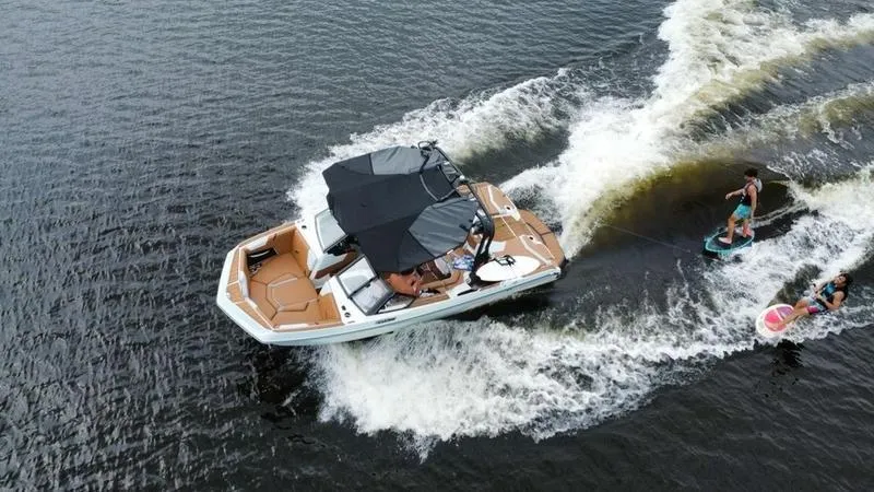 Slide: The Image of 2023 Nautique Super Air Nautique GS20 towing wakeboarders on a lake. - 3