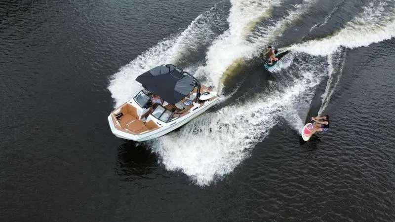 Slide: The Image of 2023 Nautique Super Air Nautique GS20 towing two wakeboarders on a lake. - 4