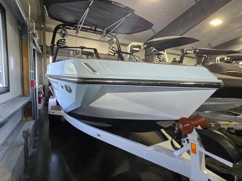 Slide: The Image of 2023 Nautique Super Air Nautique GS20 boat displayed indoors on a trailer. - 7