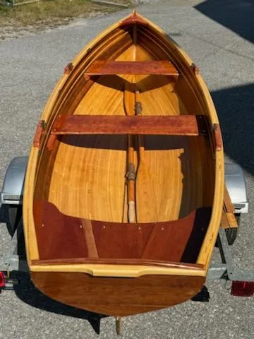 Slide: The Image of 2024 Custom Lawton Tender boat with wooden interior on a trailer. - 2