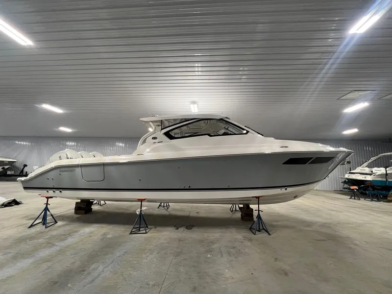 Slide: The Image of 2026 Pursuit DC 365 Dual Console boat in indoor storage facility. - 1