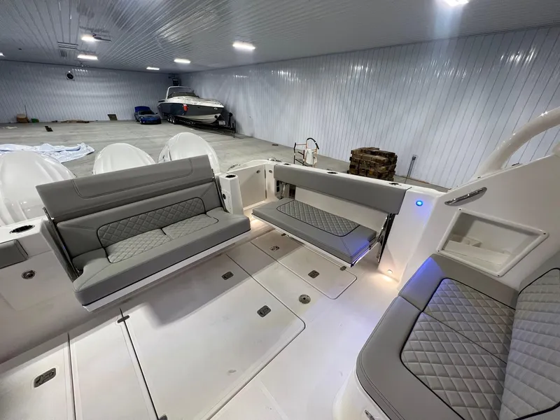 Slide: The Image of 2026 Pursuit DC 365 Dual Console boat interior with seating in a spacious, well-lit garage. - 11