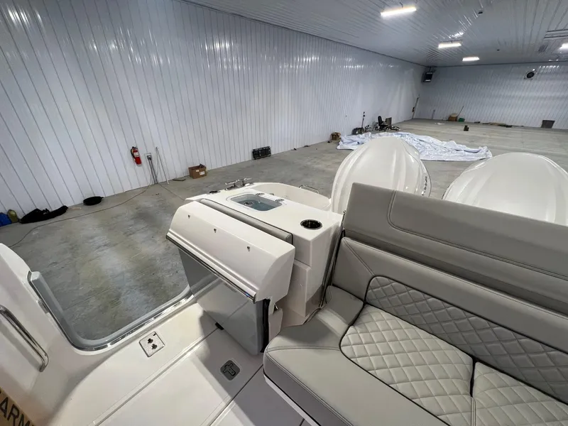Slide: The Image of 2026 Pursuit DC 365 Dual Console boat interior in a spacious, well-lit storage facility. - 12