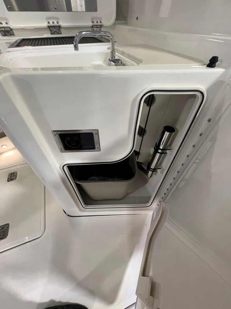 Slide: The Image of 2026 Pursuit DC 365 Dual Console boat interior with sink and storage compartment. - 16