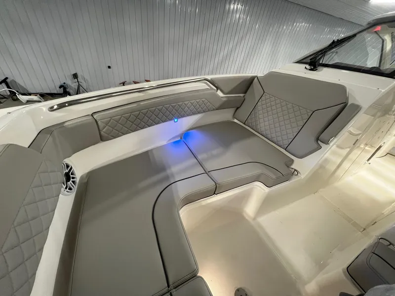Slide: The Image of 2026 Pursuit DC 365 Dual Console interior with gray seating and blue LED lighting. - 17