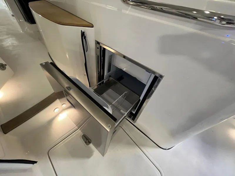 Slide: The Image of Open storage compartment on a 2026 Pursuit DC 365 Dual Console boat. - 18
