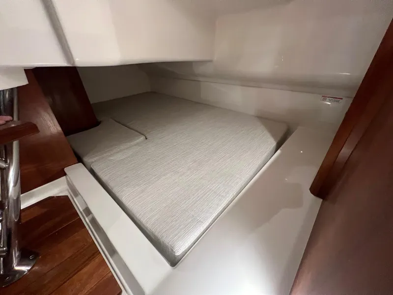 Slide: The Image of 2026 Pursuit DC 365 Dual Console cabin interior with cushioned sleeping area. - 20