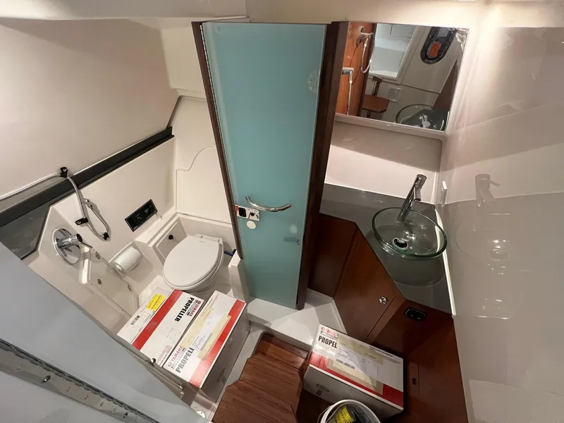 Slide: The Image of Bathroom interior of 2026 Pursuit DC 365 Dual Console boat, featuring modern fixtures and storage. - 24