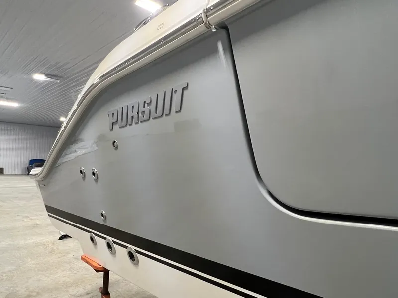 Slide: The Image of 2026 Pursuit DC 365 Dual Console boat in a spacious indoor setting. - 3