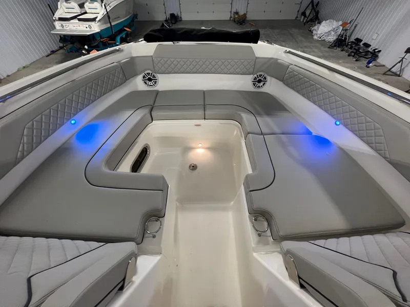 Slide: The Image of 2026 Pursuit DC 365 Dual Console boat interior with gray seating and blue LED lights. - 30