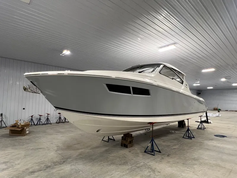 Slide: The Image of 2026 Pursuit DC 365 Dual Console boat in a spacious indoor storage facility. - 7