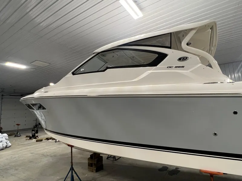 Slide: The Image of 2026 Pursuit DC 365 Dual Console boat in indoor storage facility. - 8