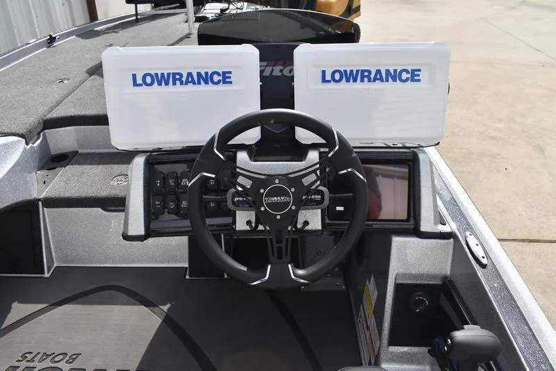 Slide: The Image of 2025 Triton 21XP Patriot boat dashboard with dual Lowrance displays and steering wheel. - 29