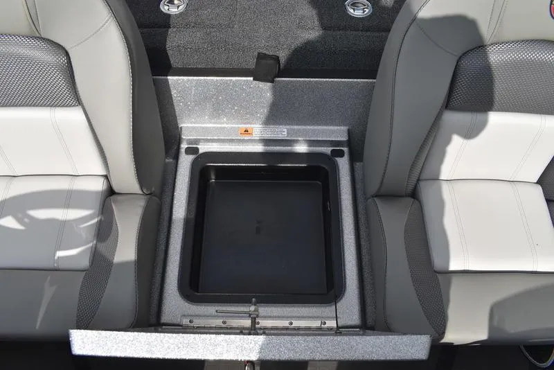 Slide: The Image of 2025 Triton 21XP Patriot boat interior with storage compartment between seats. - 33