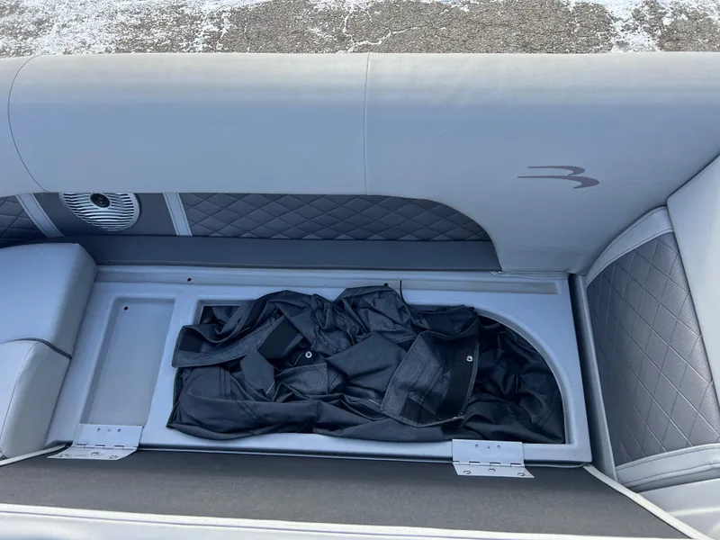 Slide: The Image of Bennington L 21 Swingback 2021 boat seat storage with black cover inside. - 11