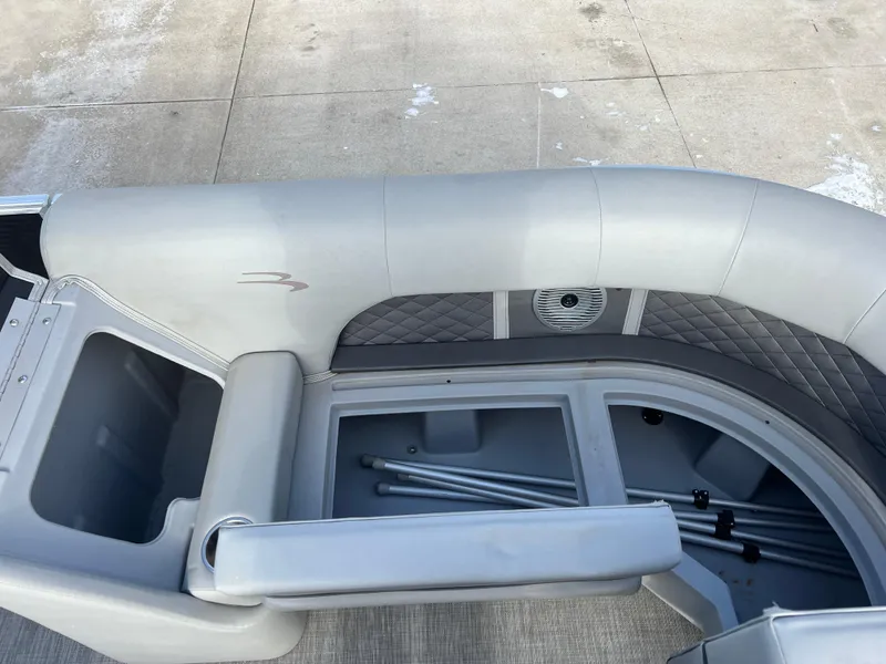 Slide: The Image of 2021 Bennington L 21 Swingback boat interior with gray seating and storage compartments. - 13