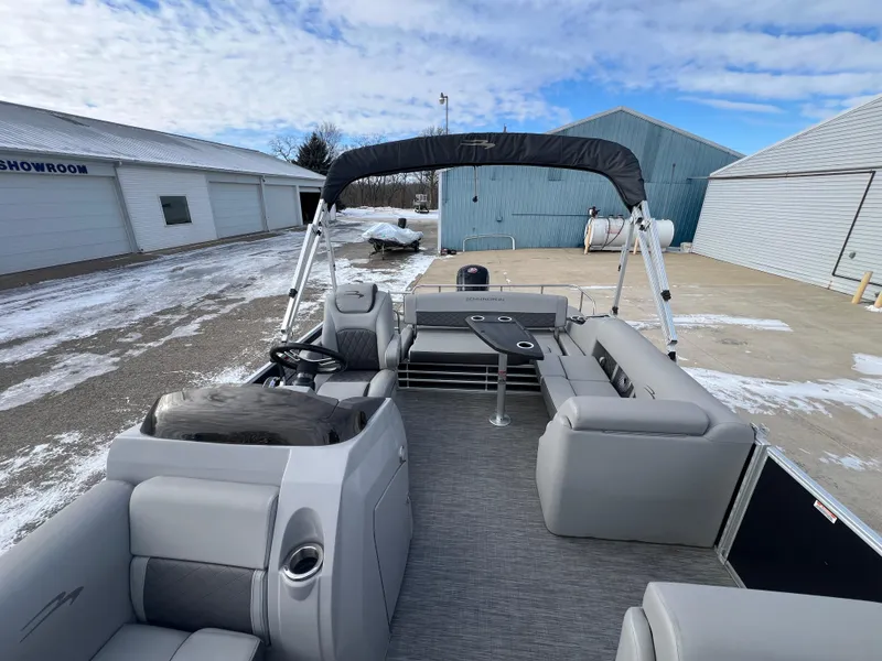 Slide: The Image of 2021 Bennington L 21 Swingback pontoon boat with gray seating, parked near showrooms. - 14