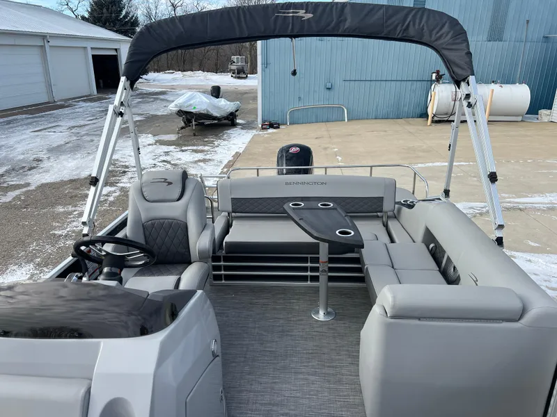 Slide: The Image of 2021 Bennington L 21 Swingback pontoon boat with seating and canopy, parked on snowy ground. - 15