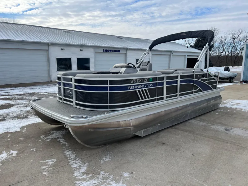 Slide: The Image of 2021 Bennington L 21 Swingback pontoon boat parked outside a showroom. - 3