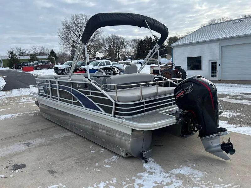 Slide: The Image of 2021 Bennington L 21 Swingback pontoon boat with outboard motor, parked on snowy driveway. - 5