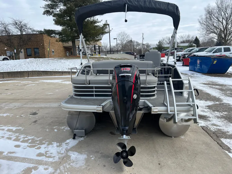 Slide: The Image of 2021 Bennington L 21 Swingback pontoon boat with outboard motor, parked on snowy pavement. - 6