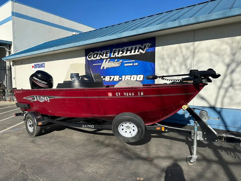 Slide: The Image of 2015 Lund 1750 Rebel XS SS boat on trailer, parked outside a building. - 2
