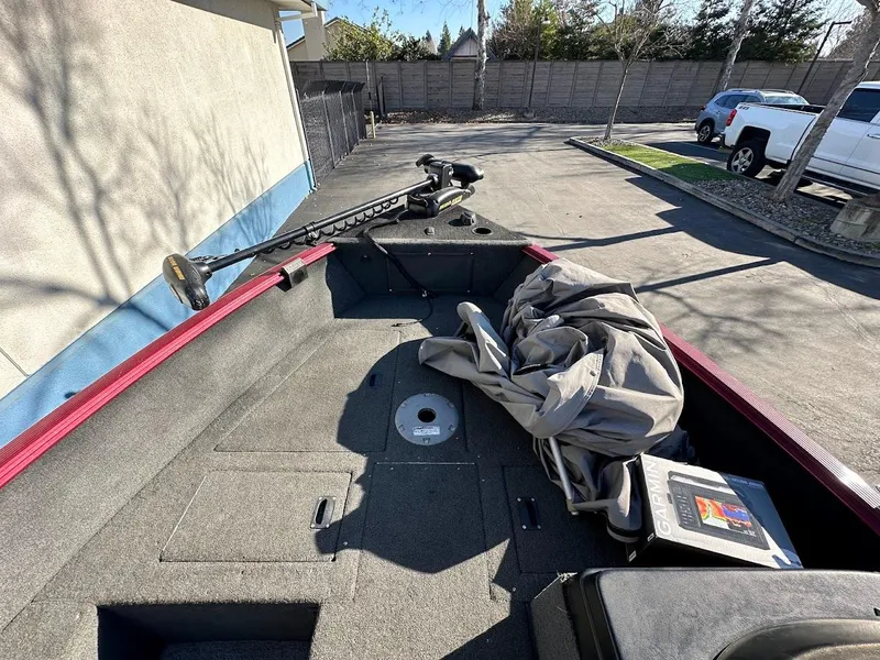 Slide: The Image of 2015 Lund 1750 Rebel XS SS boat interior with equipment and cover, parked outdoors. - 25