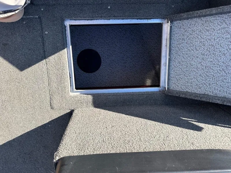 Slide: The Image of 2015 Lund 1750 Rebel XS SS boat storage compartment with open lid. - 30