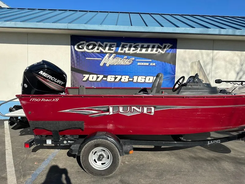 Slide: The Image of 2015 Lund 1750 Rebel XS SS boat with Mercury engine, parked outside dealership. - 7